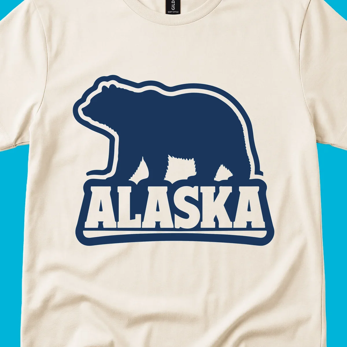 A vintage Alaska bear emblem featuring a navy bear silhouette above the word ALASKA, all with a white outline.