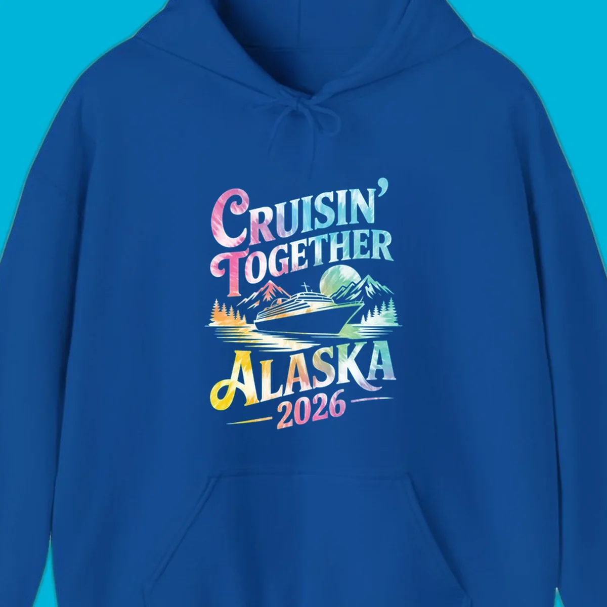 A tie-dye graphic featuring a cruise ship, mountains, and trees, with the text 'CRUISIN' TOGETHER ALASKA 2026'. This alaska-cruise-2026-tie-dye design shows a scenic view.