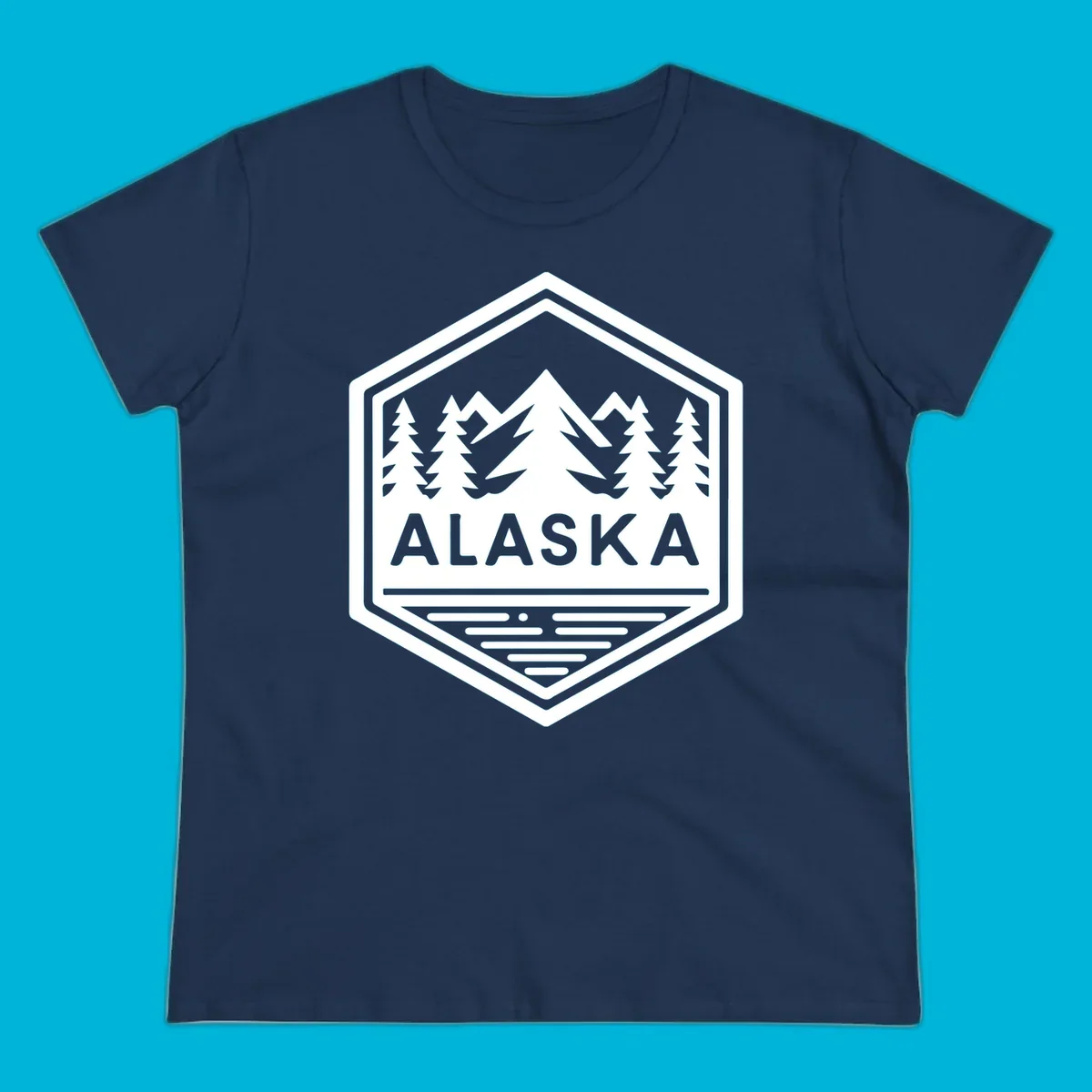 An Alaska mountain lake badge design in a hexagon shape, showing mountains, pine trees, and a lake below the ALASKA text.