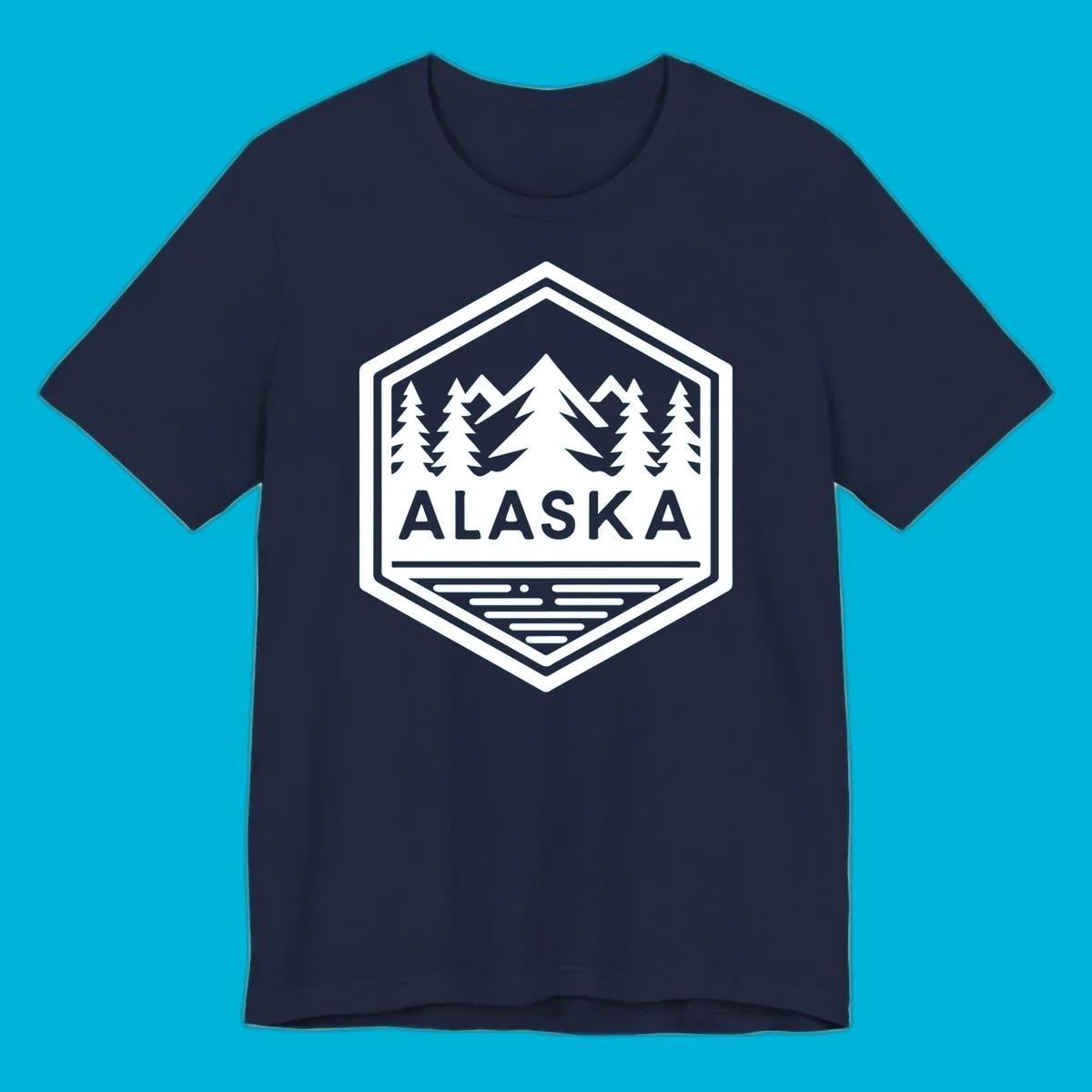 An Alaska mountain lake badge design in a hexagon shape, showing mountains, pine trees, and a lake below the ALASKA text.
