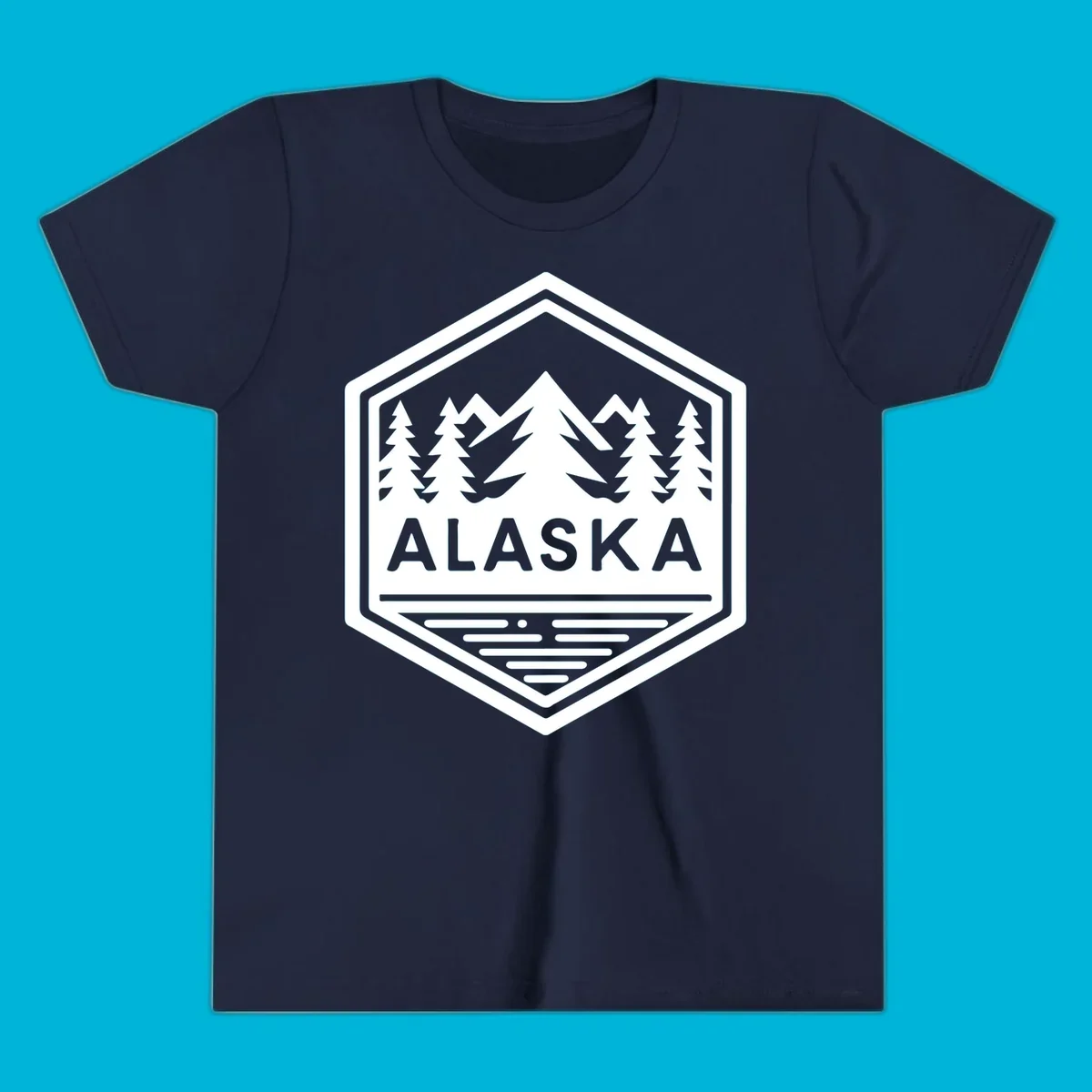 An Alaska mountain lake badge design in a hexagon shape, showing mountains, pine trees, and a lake below the ALASKA text.