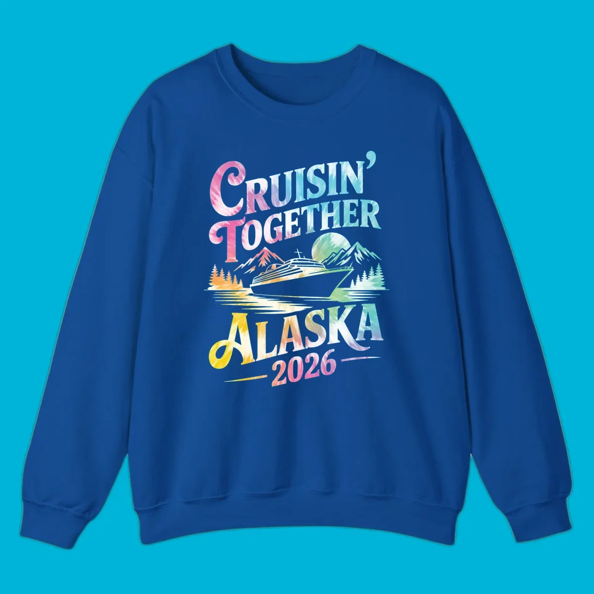 A tie-dye graphic featuring a cruise ship, mountains, and trees, with the text 'CRUISIN' TOGETHER ALASKA 2026'. This alaska-cruise-2026-tie-dye design shows a scenic view.