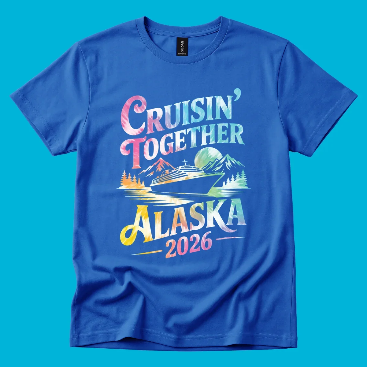 A tie-dye graphic featuring a cruise ship, mountains, and trees, with the text 'CRUISIN' TOGETHER ALASKA 2026'. This alaska-cruise-2026-tie-dye design shows a scenic view.