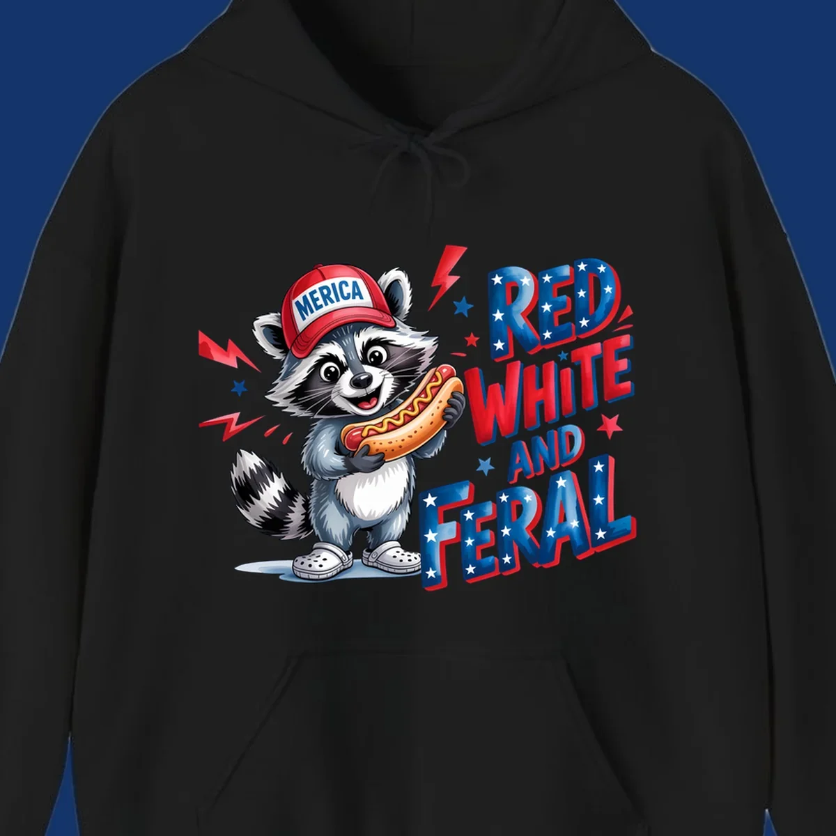 A cartoon raccoon wearing a 'MERICA' hat and holding a hot dog, next to text 'RED WHITE AND FERAL'. This is a raccoon-red-white-feral design.