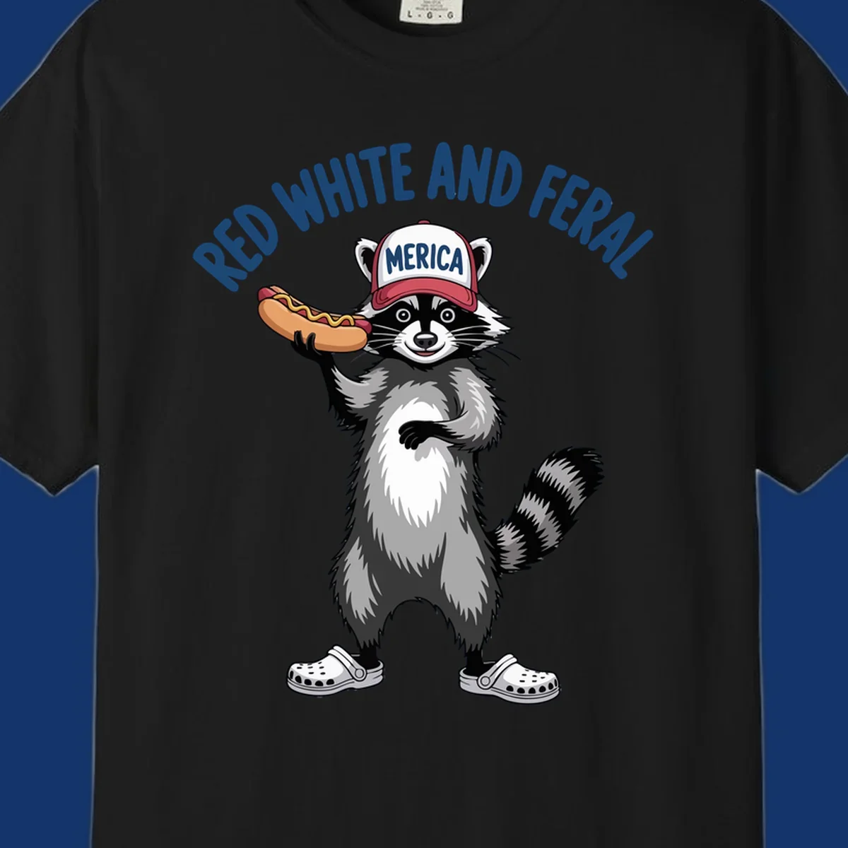 A patriotic raccoon in a MERICA hat and Crocs holds a hot dog, with 'RED WHITE AND FERAL' text. Features the red-white-feral-raccoon concept.