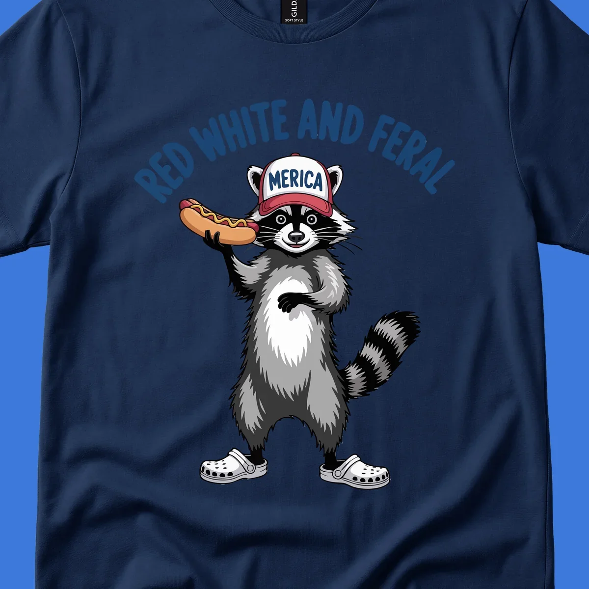 A patriotic raccoon in a MERICA hat and Crocs holds a hot dog, with 'RED WHITE AND FERAL' text. Features the red-white-feral-raccoon concept.