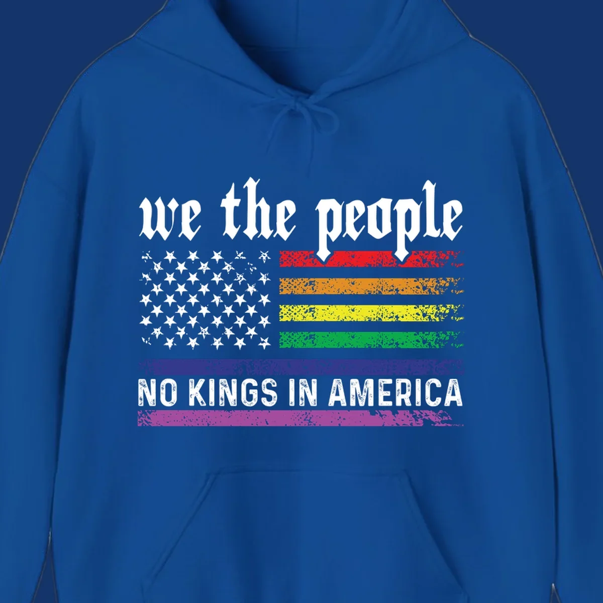 A distressed American flag with rainbow stripes and white stars, featuring 'we the people' and 'NO KINGS IN AMERICA' text.