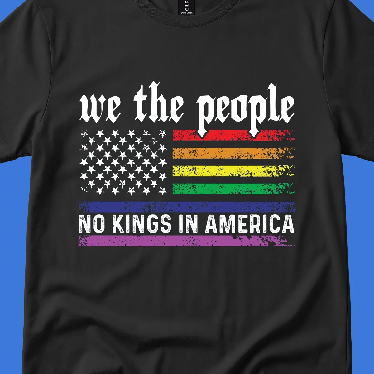 A distressed American flag with rainbow stripes and white stars, featuring 'we the people' and 'NO KINGS IN AMERICA' text.