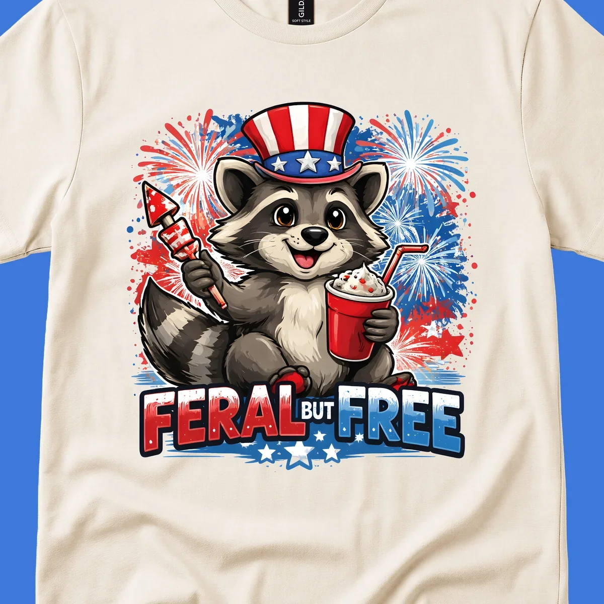 A cartoon raccoon in an Uncle Sam hat holds a firework and drink, with red, white, and blue fireworks and "FERAL BUT FREE" text.