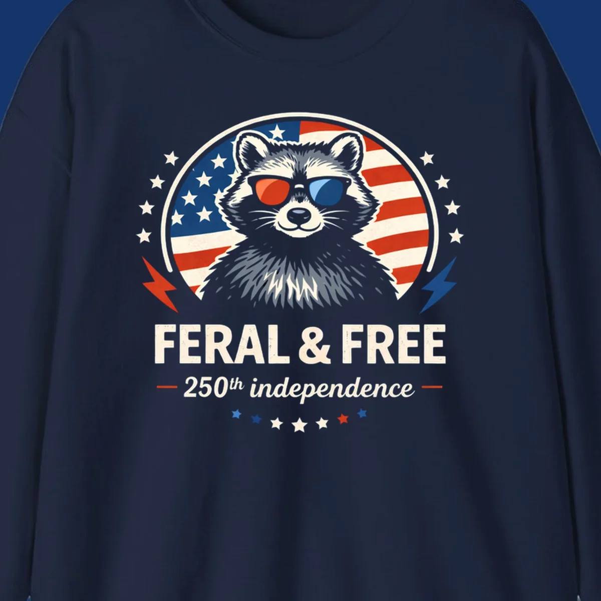 A patriotic design with a raccoon in red and blue sunglasses against an American flag, with text 'Feral & Free 250th Independence'.