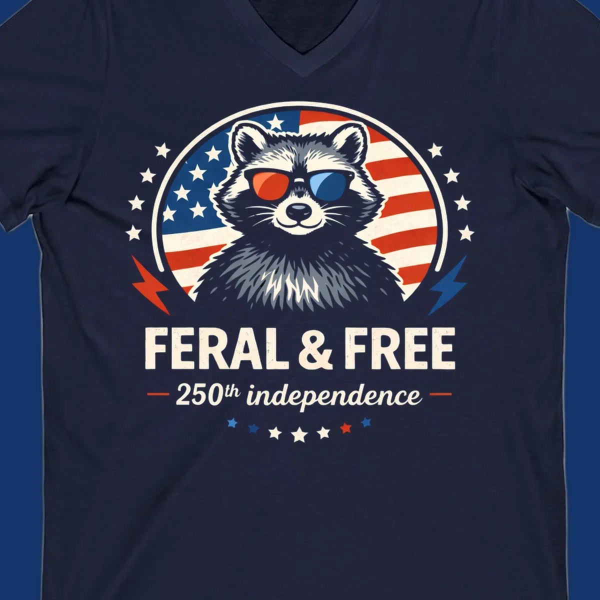 A patriotic design with a raccoon in red and blue sunglasses against an American flag, with text 'Feral & Free 250th Independence'.