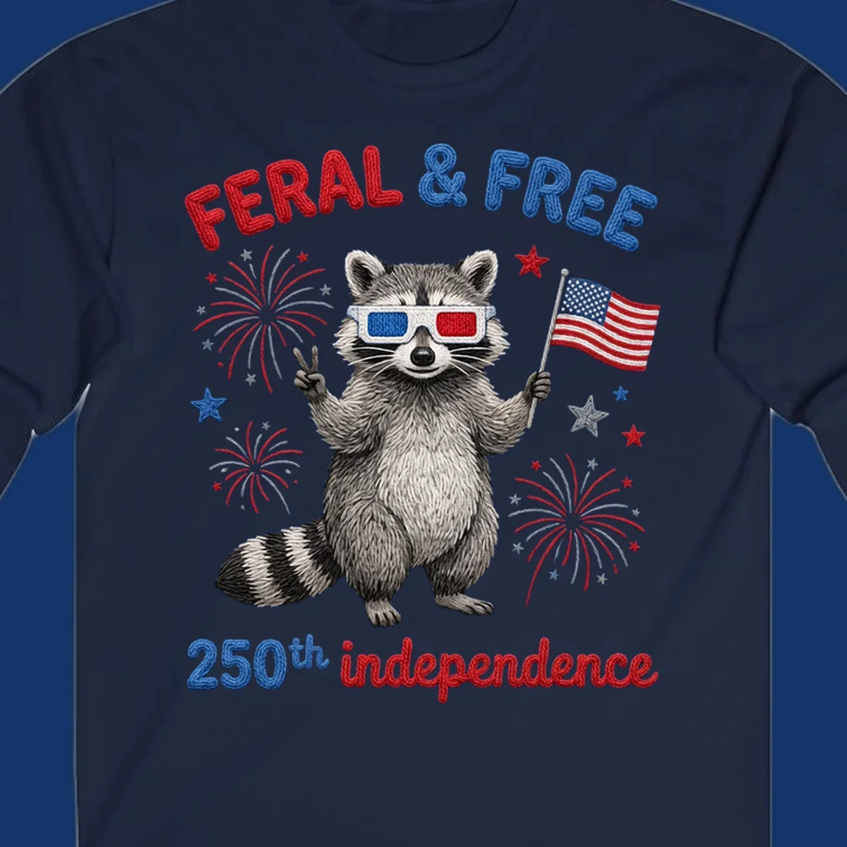 A playful raccoon in 3D glasses holds an American flag, surrounded by fireworks and stars, with "FERAL & FREE 250th independence".