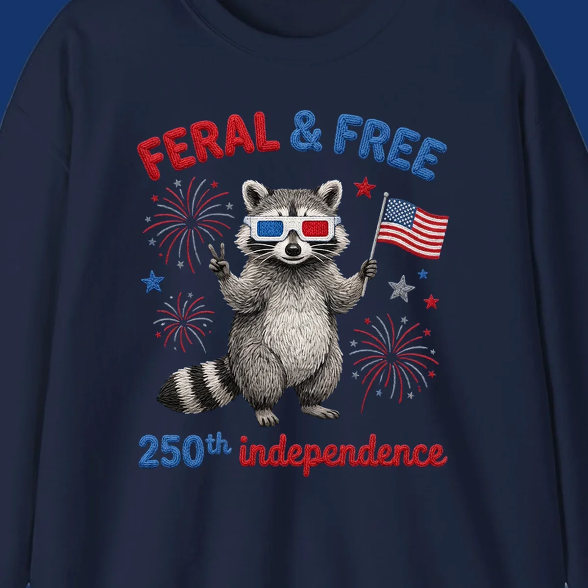 A playful raccoon in 3D glasses holds an American flag, surrounded by fireworks and stars, with "FERAL & FREE 250th independence".