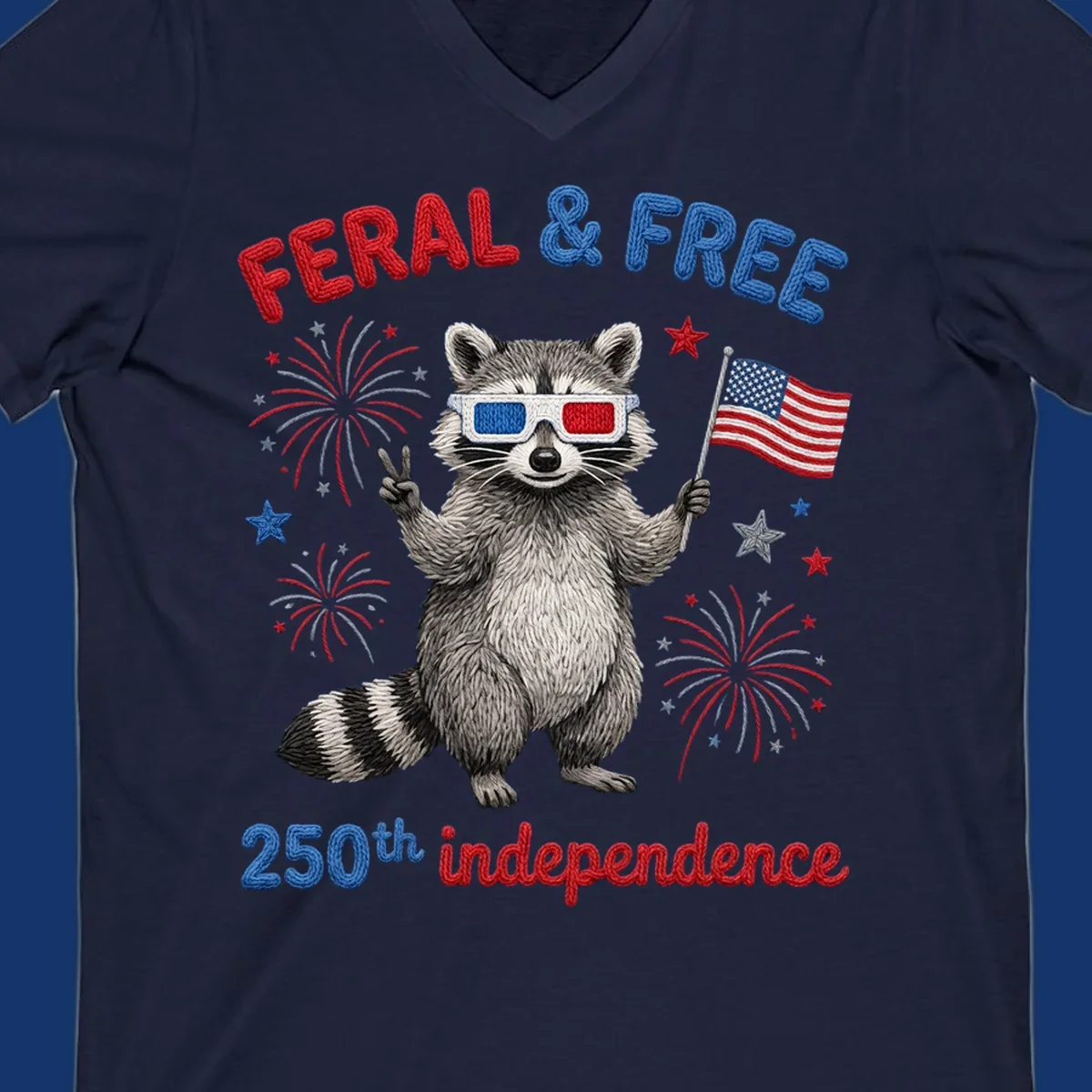 A playful raccoon in 3D glasses holds an American flag, surrounded by fireworks and stars, with "FERAL & FREE 250th independence".