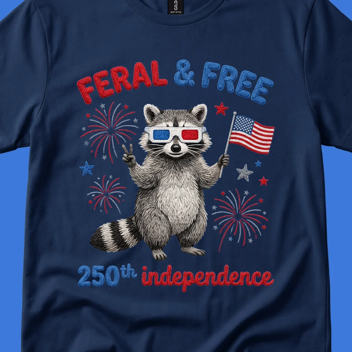 A "FERAL & FREE" raccoon in 3D glasses holds an American flag, surrounded by fireworks, celebrating 250th independence.