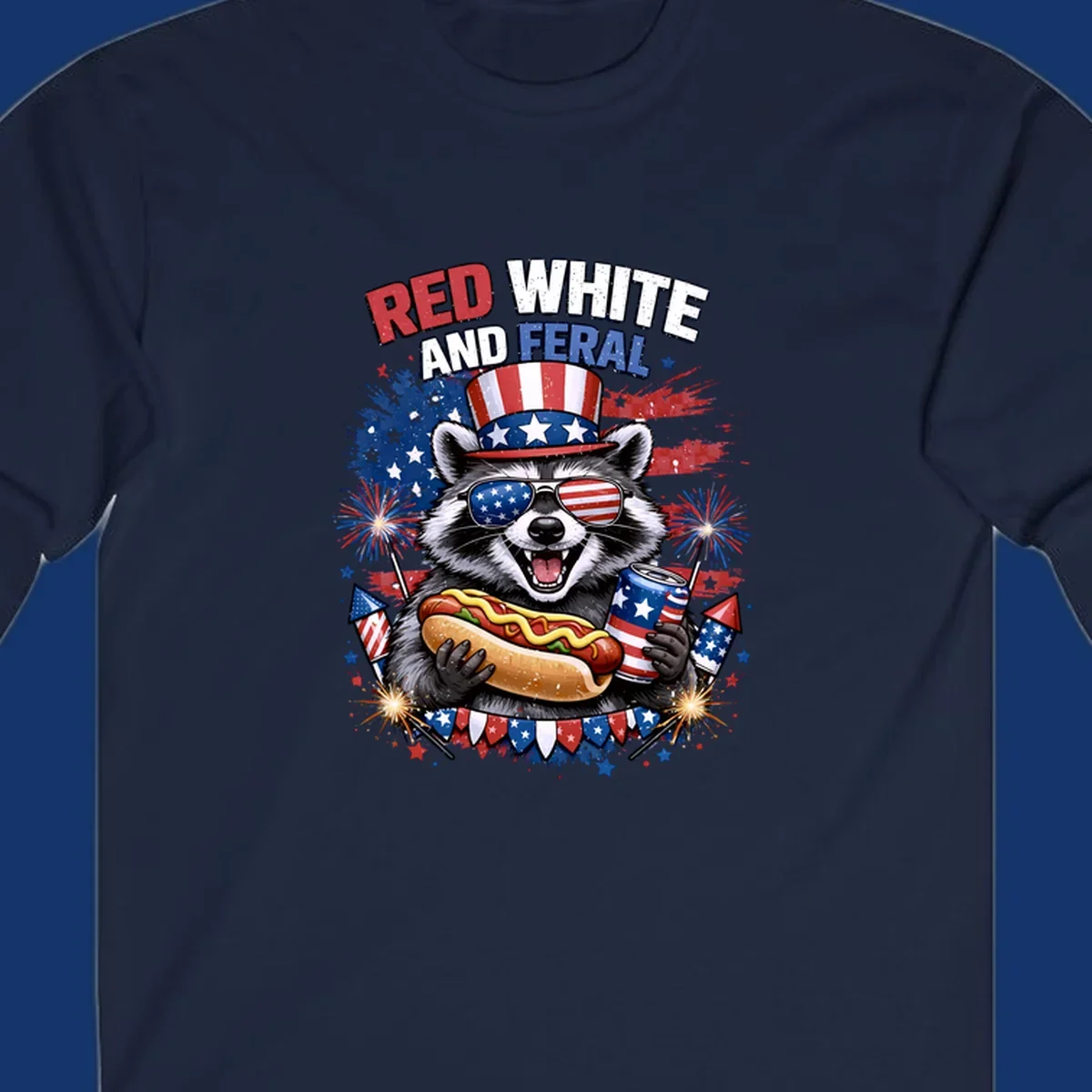 A patriotic raccoon wearing an American flag top hat and sunglasses, holding a hot dog and soda can, with the text 'RED WHITE AND FERAL' and fireworks.