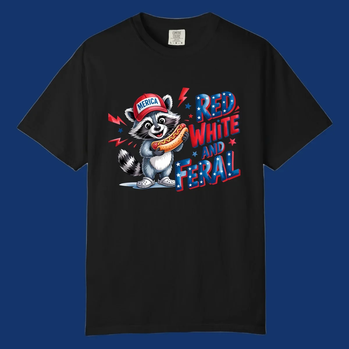 A cartoon raccoon wearing a 'MERICA' hat and holding a hot dog, next to text 'RED WHITE AND FERAL'. This is a raccoon-red-white-feral design.