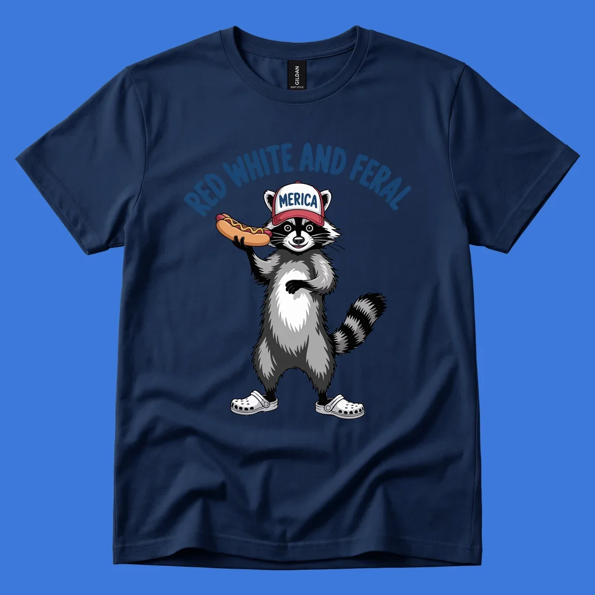 A patriotic raccoon in a MERICA hat and Crocs holds a hot dog, with 'RED WHITE AND FERAL' text. Features the red-white-feral-raccoon concept.