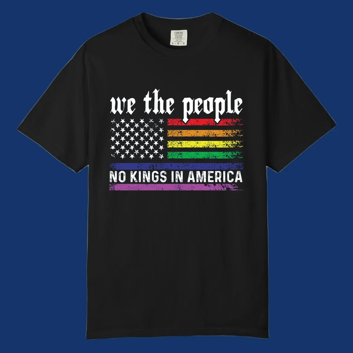 A distressed American flag with rainbow stripes and white stars, featuring 'we the people' and 'NO KINGS IN AMERICA' text.