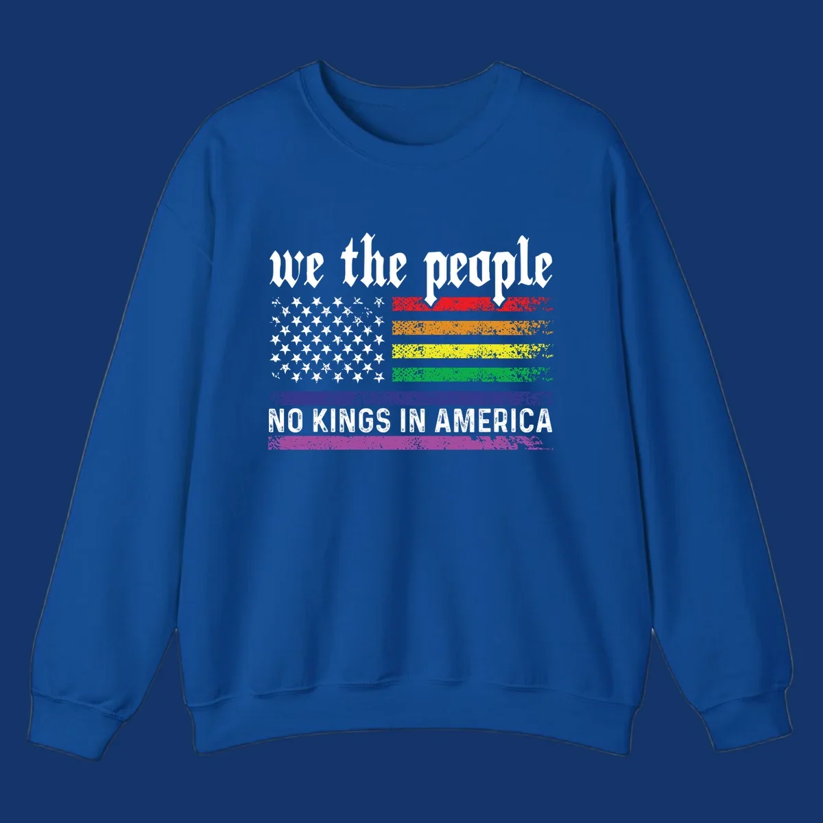 A distressed American flag with rainbow stripes and white stars, featuring 'we the people' and 'NO KINGS IN AMERICA' text.