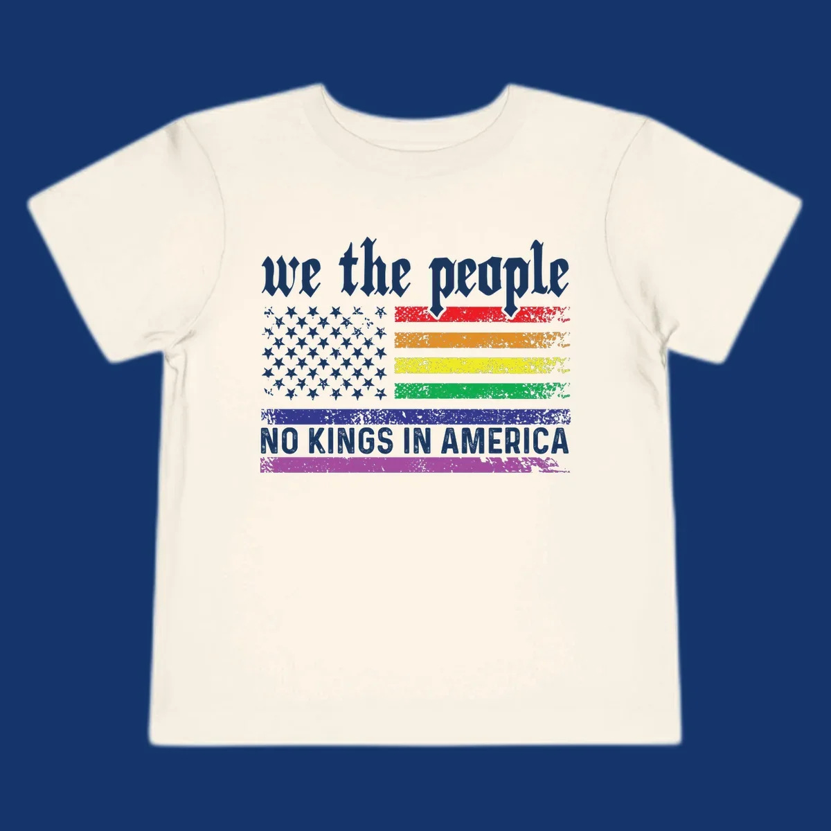 A distressed American flag with rainbow stripes and white stars, featuring 'we the people' and 'NO KINGS IN AMERICA' text.