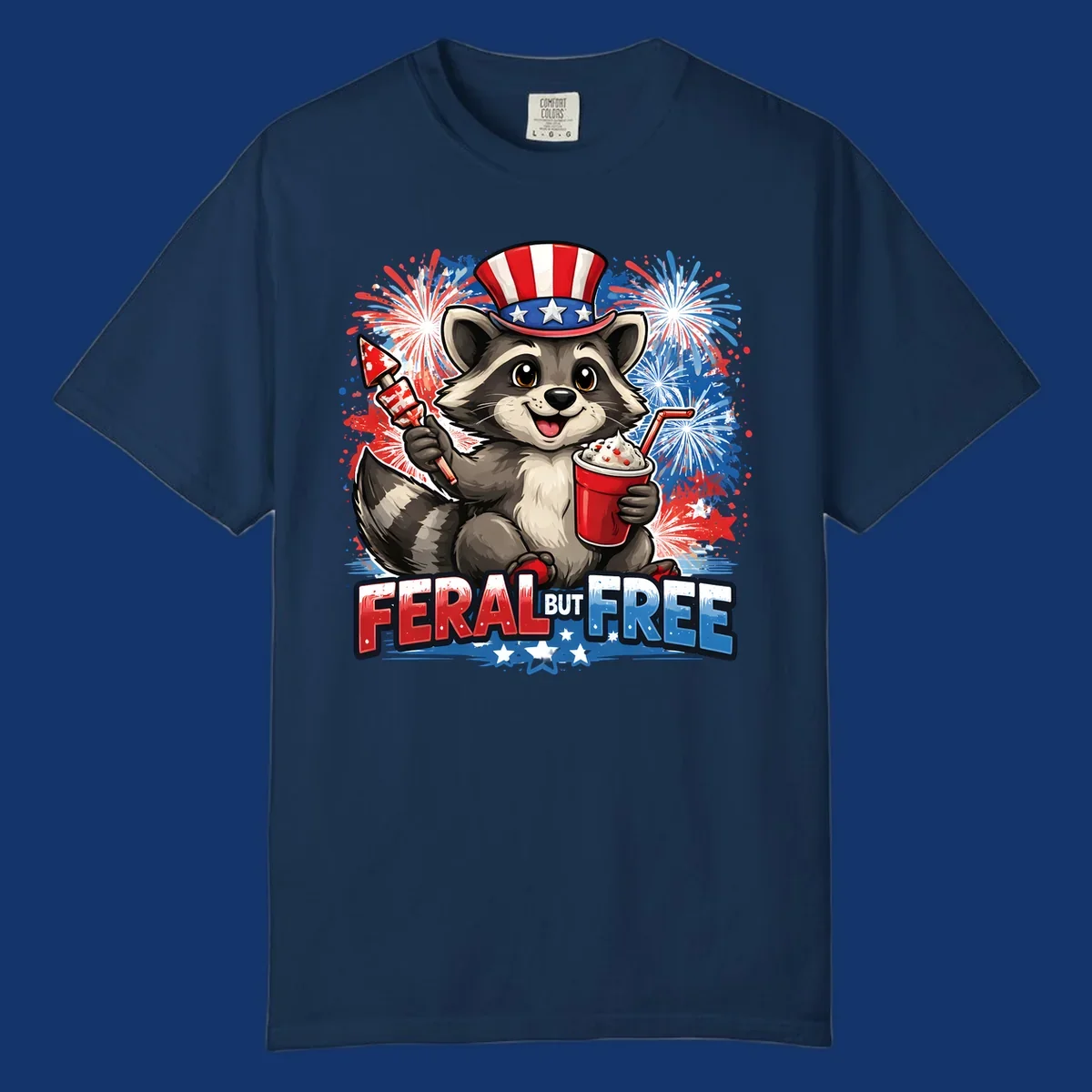 A cartoon raccoon in an Uncle Sam hat holds a firework and drink, with red, white, and blue fireworks and "FERAL BUT FREE" text.