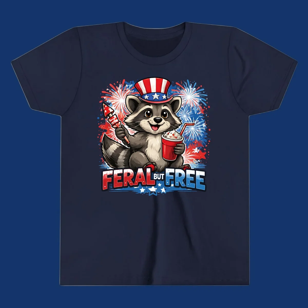 A cartoon raccoon in an Uncle Sam hat holds a firework and drink, with red, white, and blue fireworks and "FERAL BUT FREE" text.