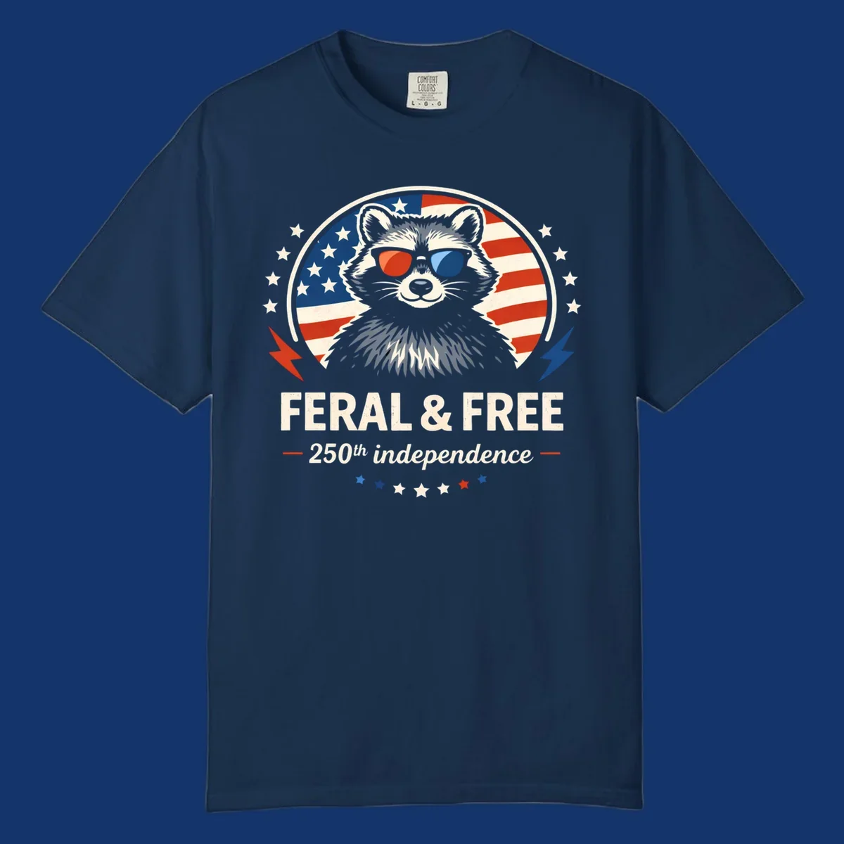 A patriotic design with a raccoon in red and blue sunglasses against an American flag, with text 'Feral & Free 250th Independence'.