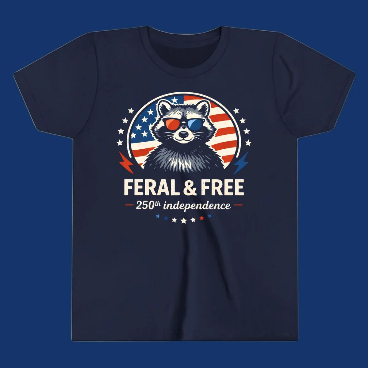 A patriotic design with a raccoon in red and blue sunglasses against an American flag, with text 'Feral & Free 250th Independence'.