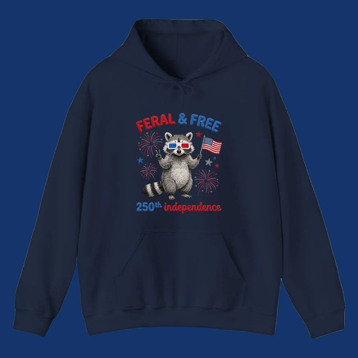 A playful raccoon in 3D glasses holds an American flag, surrounded by fireworks and stars, with "FERAL & FREE 250th independence".