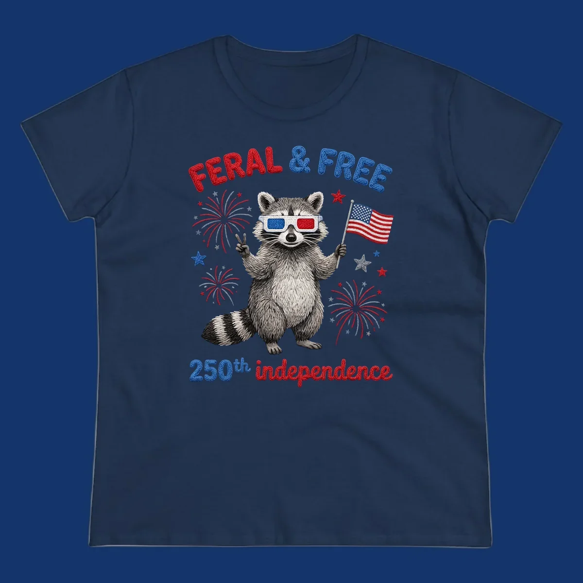 A playful raccoon in 3D glasses holds an American flag, surrounded by fireworks and stars, with "FERAL & FREE 250th independence".