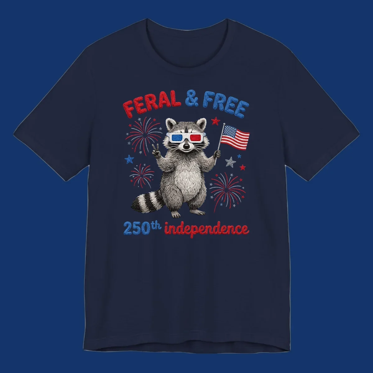 A playful raccoon in 3D glasses holds an American flag, surrounded by fireworks and stars, with "FERAL & FREE 250th independence".