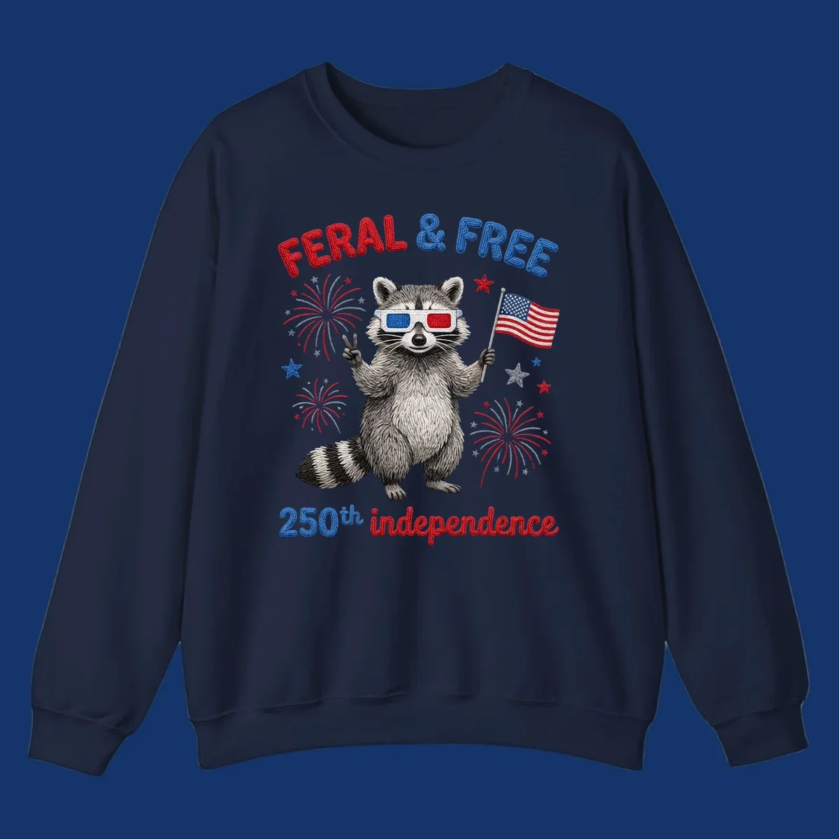 A playful raccoon in 3D glasses holds an American flag, surrounded by fireworks and stars, with "FERAL & FREE 250th independence".