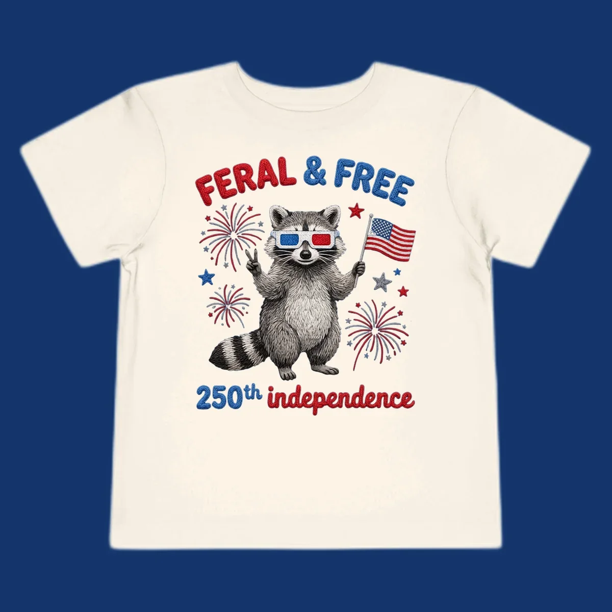 A "FERAL & FREE" raccoon in 3D glasses holds an American flag, surrounded by fireworks, celebrating 250th independence.