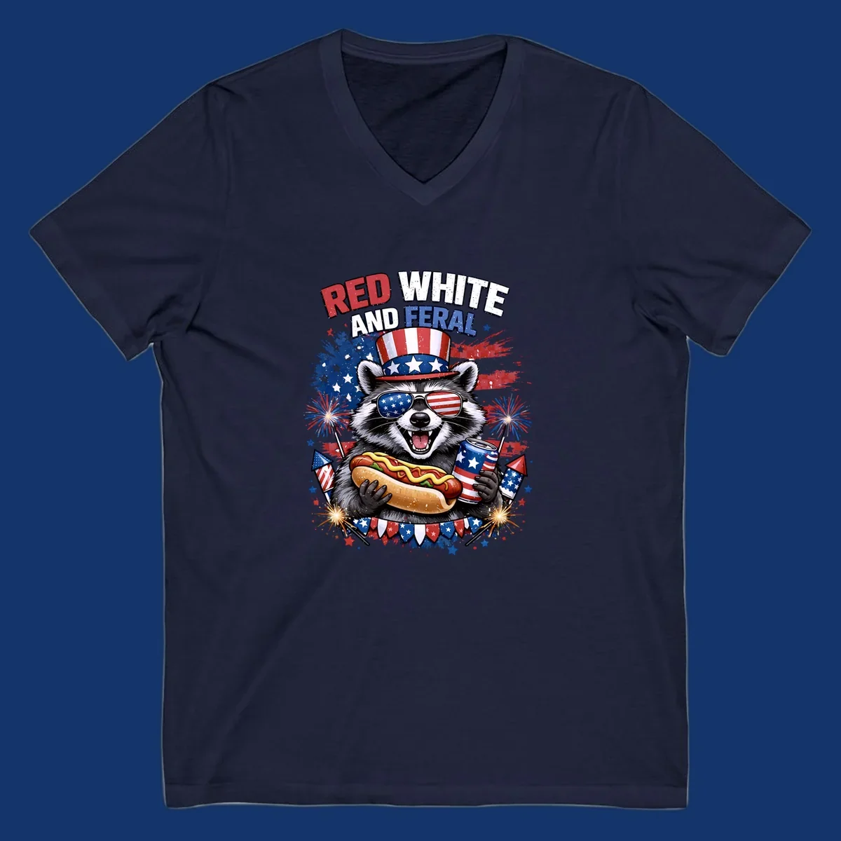 A patriotic raccoon wearing an American flag top hat and sunglasses, holding a hot dog and soda can, with the text 'RED WHITE AND FERAL' and fireworks.