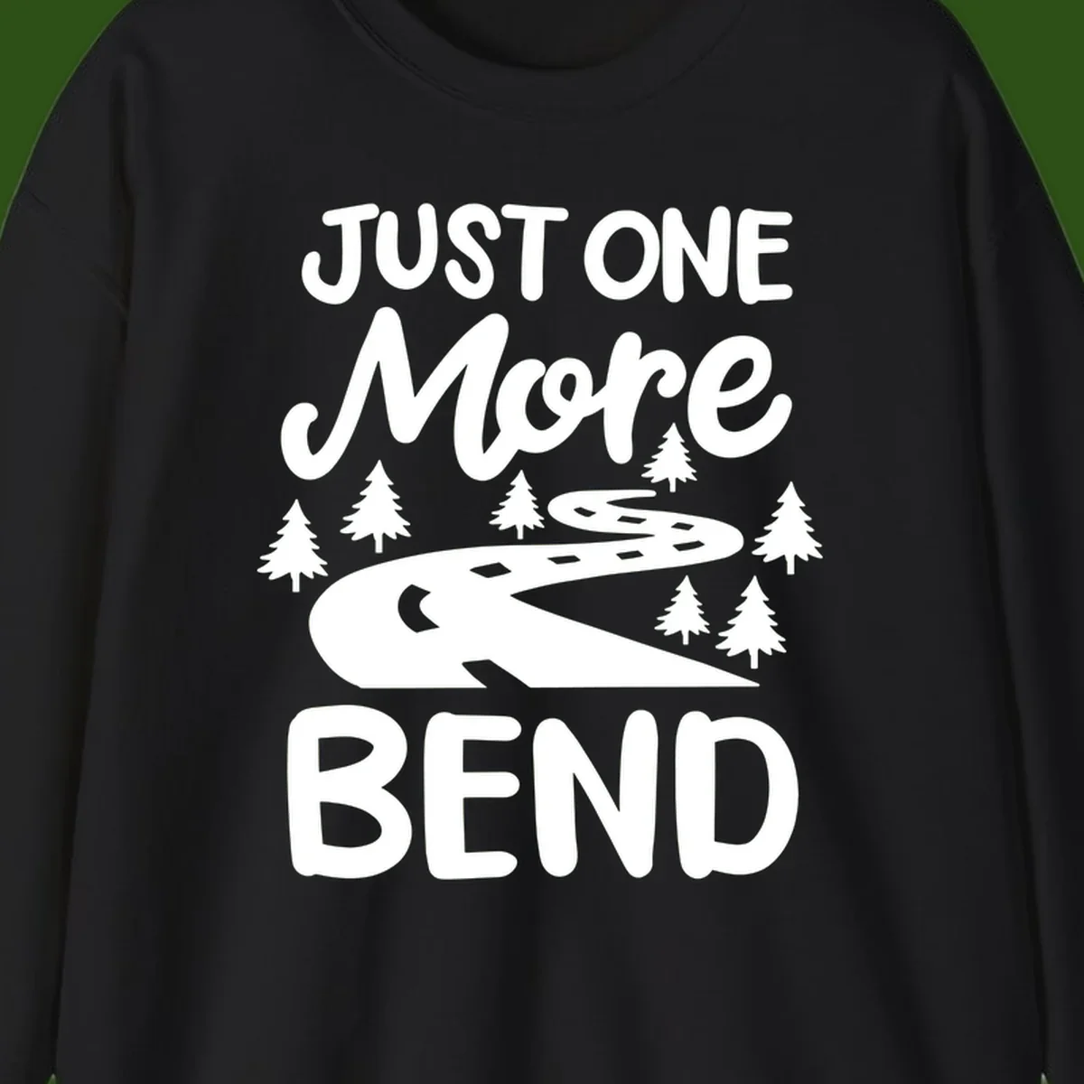 White design on gray background showing a winding road through evergreen trees with cursive text reading 'Just One More Bend'
