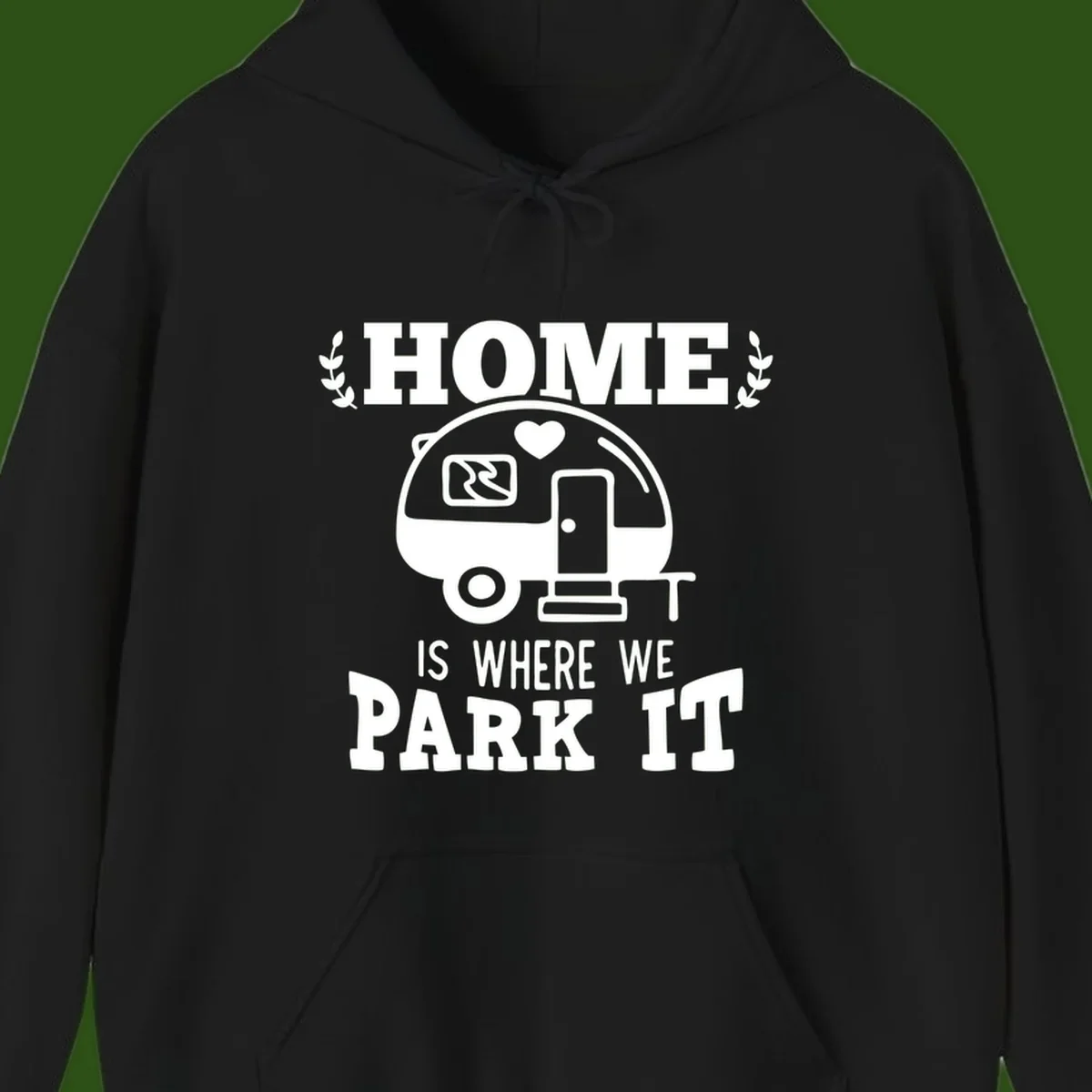 Vintage travel trailer illustration with 'Home Is Where We Park It' text and laurel wreaths on gray background