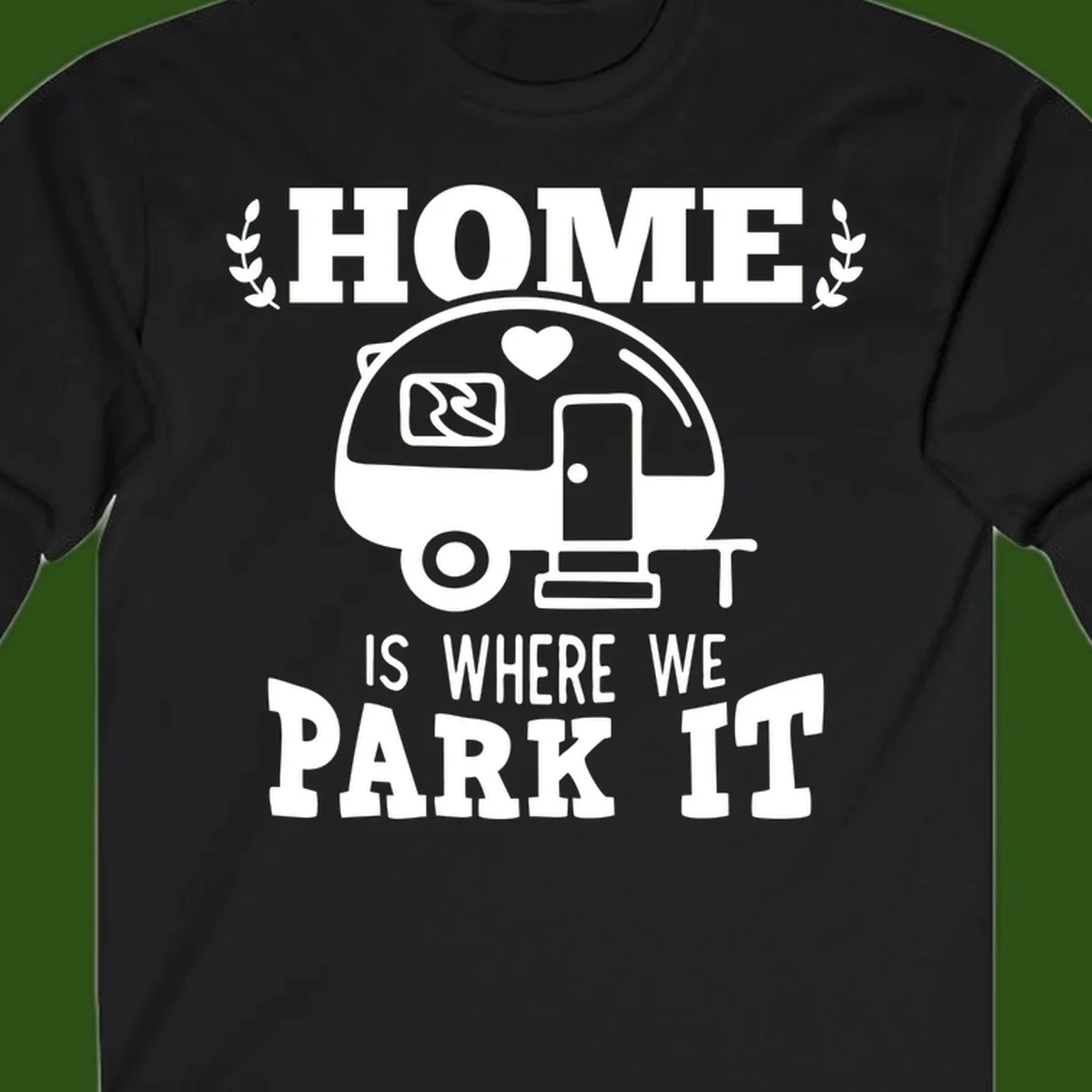 Vintage travel trailer illustration with 'Home Is Where We Park It' text and laurel wreaths on gray background
