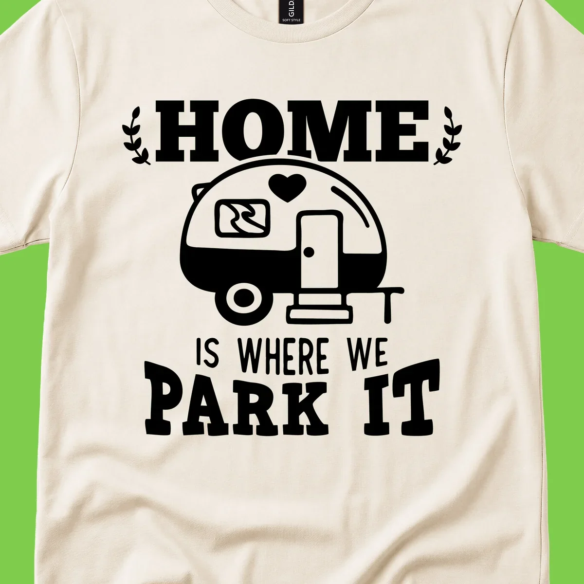 Vintage travel trailer illustration with 'Home Is Where We Park It' text and laurel wreaths on gray background