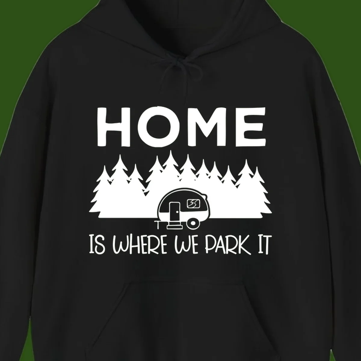 Home is where we park it design with travel trailer and forest trees on gray background