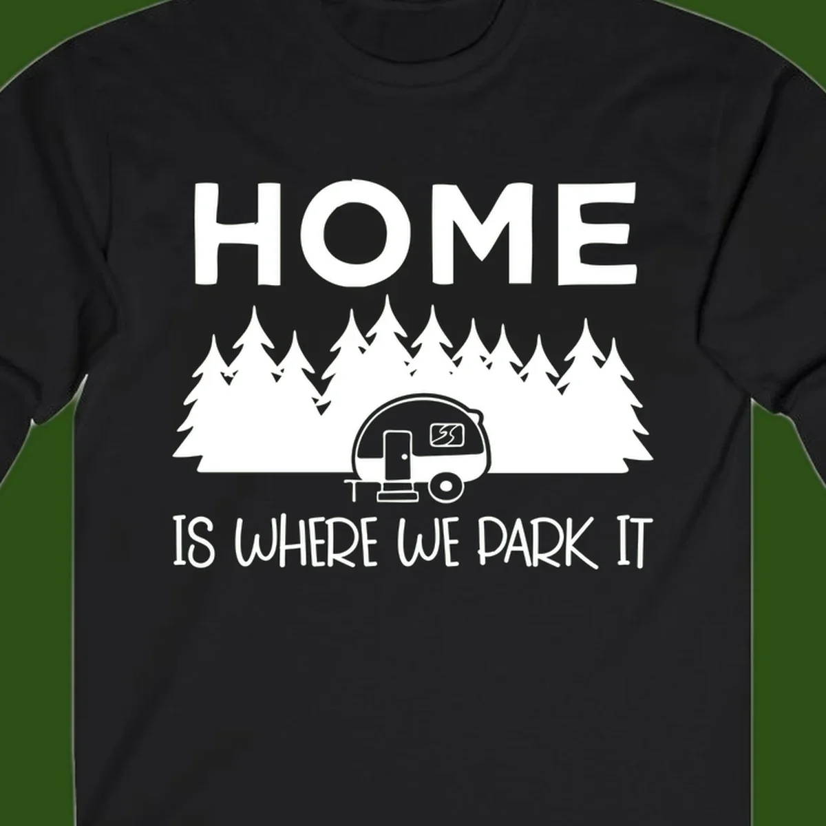 Home is where we park it design with travel trailer and forest trees on gray background