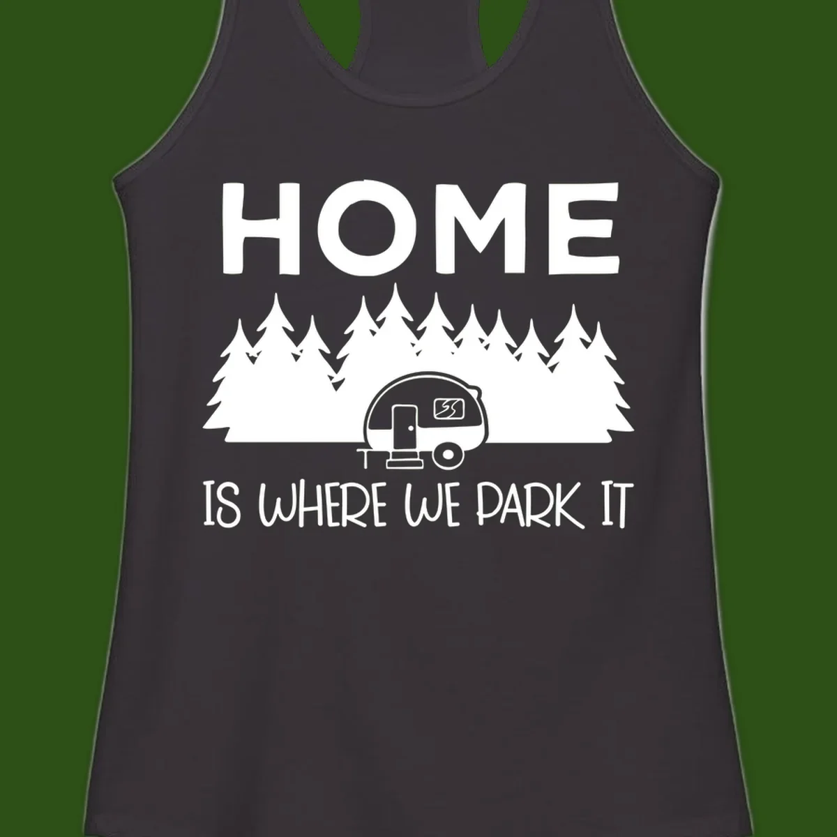 Home is where we park it design with travel trailer and forest trees on gray background