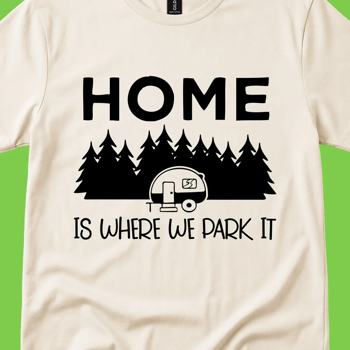 Home is where we park it design with travel trailer and forest trees on gray background