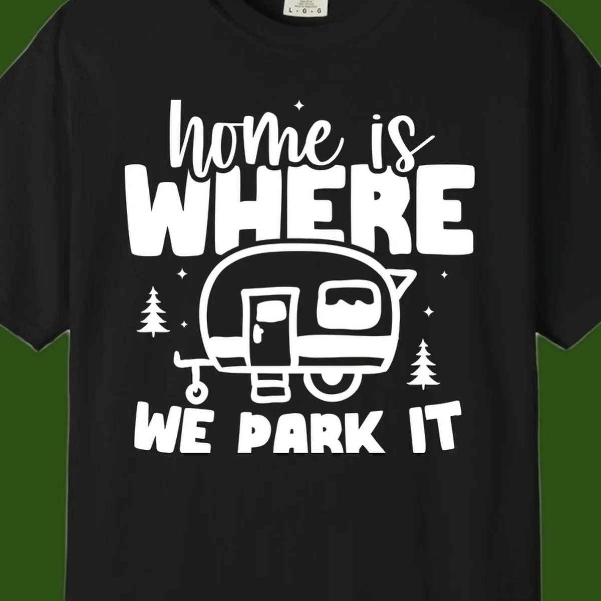 Retro-style design with 'home is where we park it' text and vintage travel trailer illustration surrounded by pine trees and sparkles