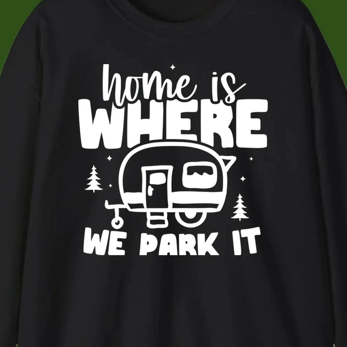 Retro-style design with 'home is where we park it' text and vintage travel trailer illustration surrounded by pine trees and sparkles