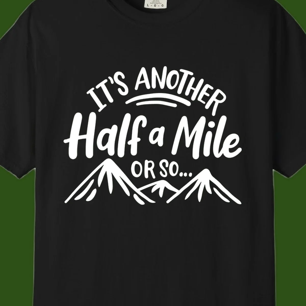 White text reading 'It's Another Half a Mile Or So...' with illustrated snow-capped mountains below on gray background