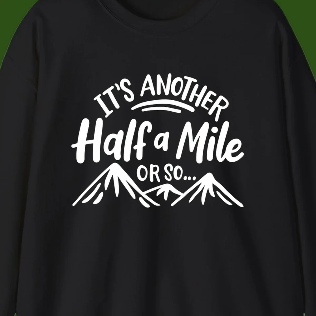 White text reading 'It's Another Half a Mile Or So...' with illustrated snow-capped mountains below on gray background