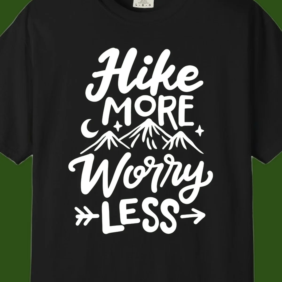 White lettered design reading 'Hike More Worry Less' with mountain peaks, moon, and stars on gray background