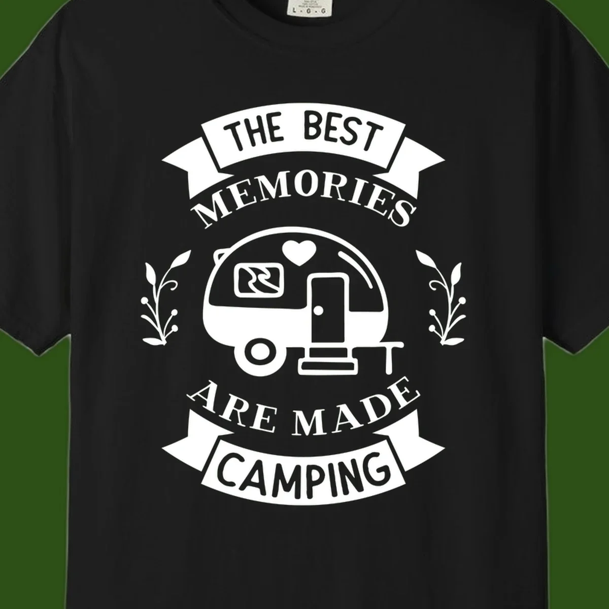 Vintage badge design with travel trailer and heart, text reading 'The Best Memories Are Made Camping' with decorative botanical branches