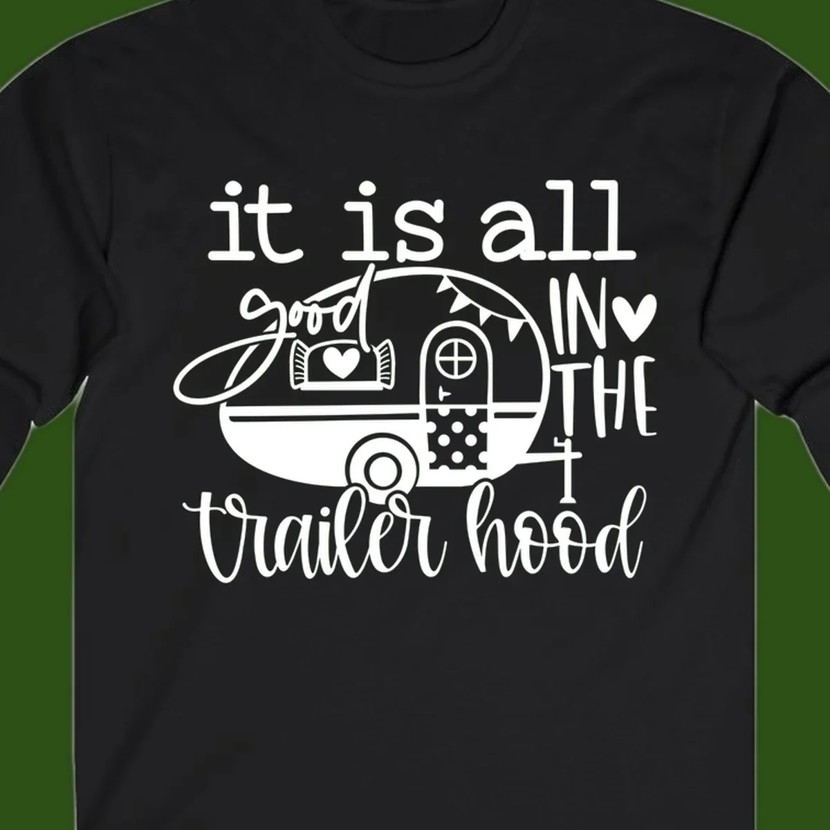 Vintage trailer illustration with decorative hearts and bunting, text reading 'it is all good in the trailer hood' in retro style